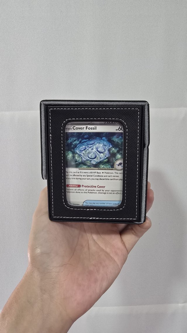 Jack holding his Cover Fossil card, sleeved in a card display case