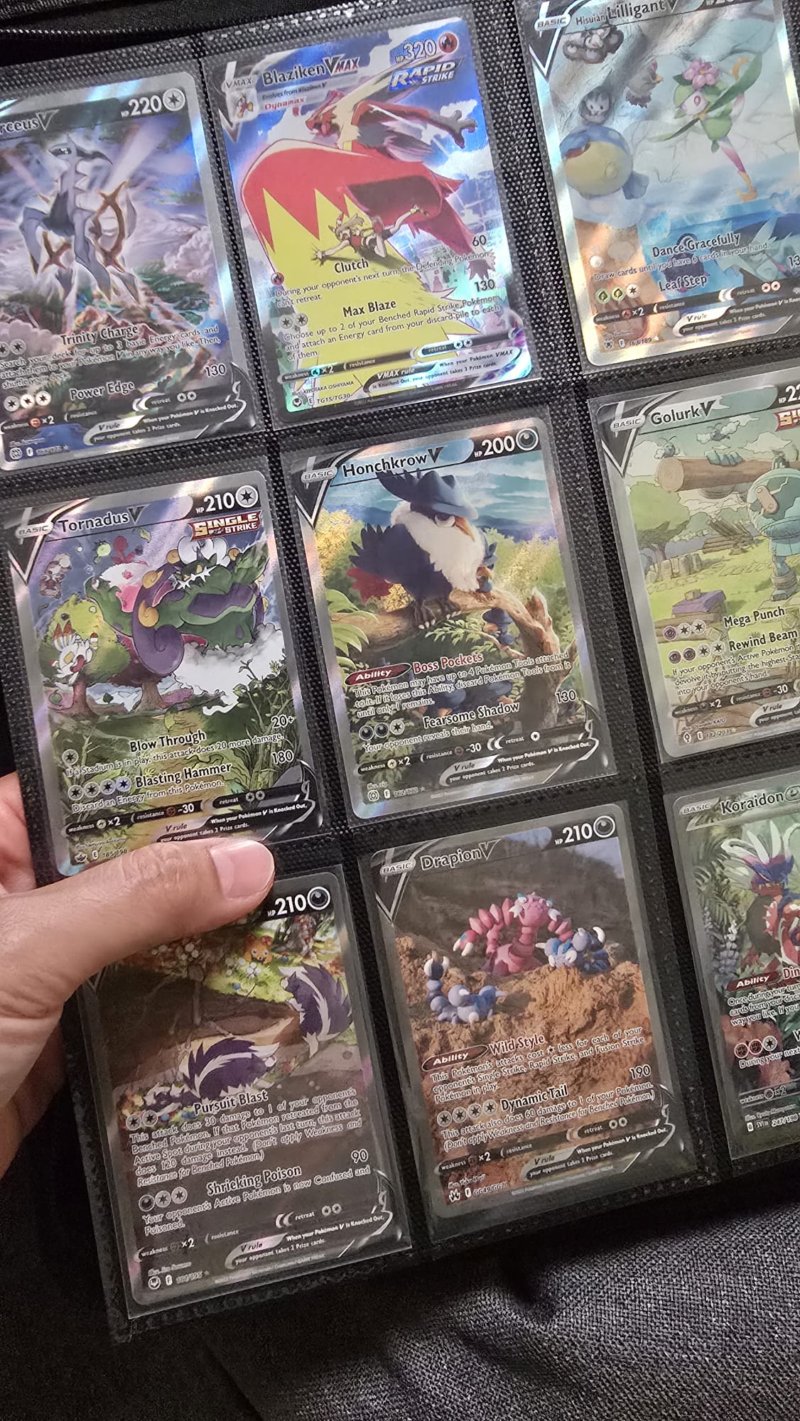 Jack&rsquo;s hand holding open a binder page of Pok&eacute;mon TCG cards
