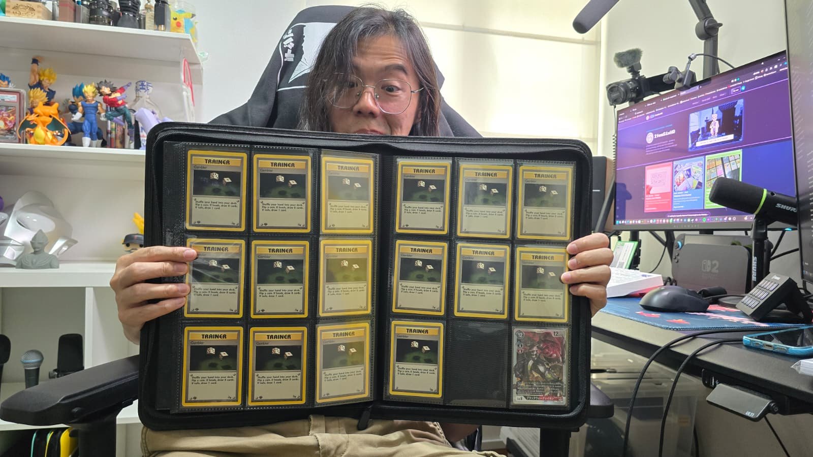 Jack peeking over a zip binder full of first edition Gambler Trainer cards
