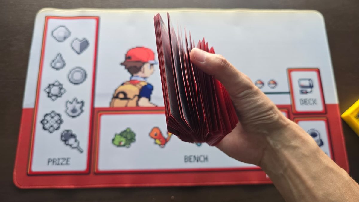 Shuffling a sleeved Pokémon TCG deck over the playmat