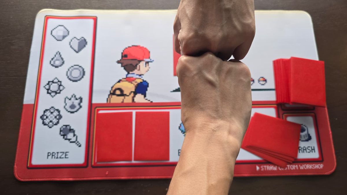 Two fists meeting in a fist bump over the playmat